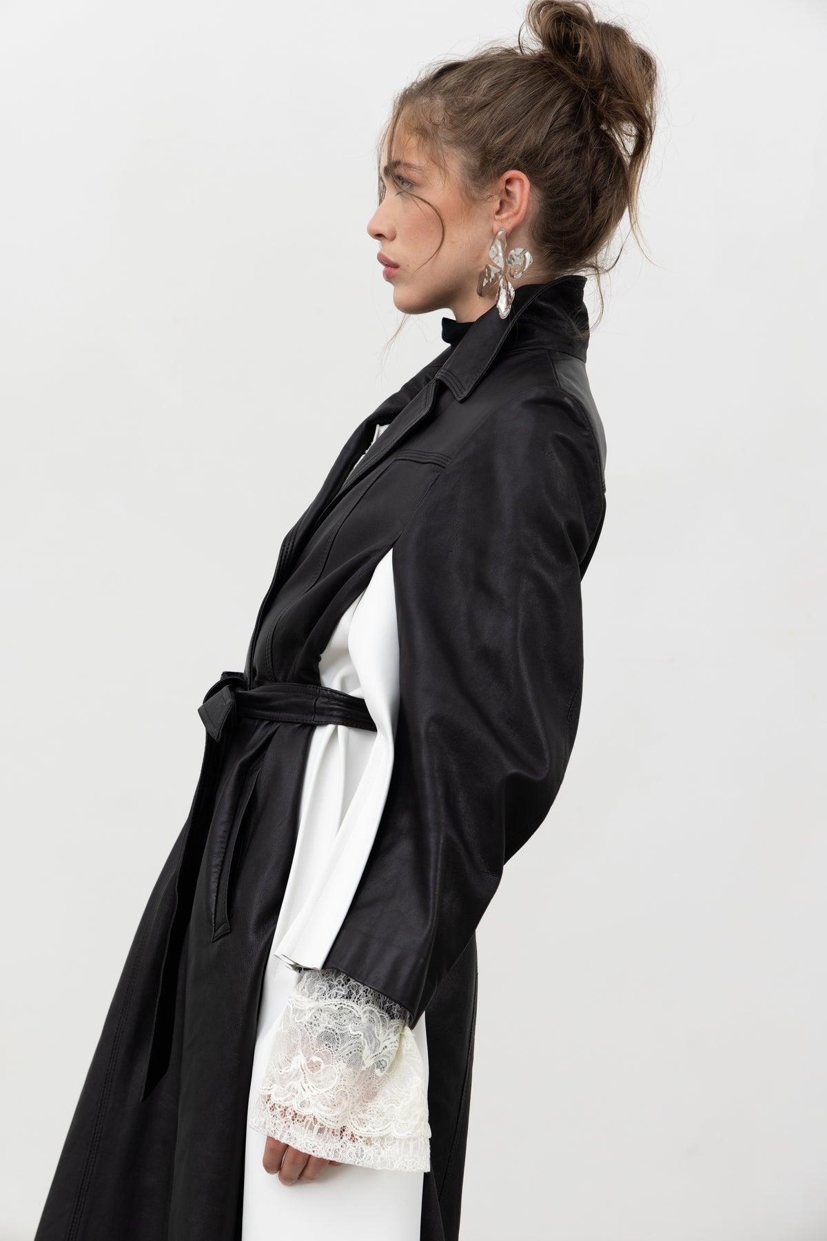 Profile view of the belted Luxifer black leather trench