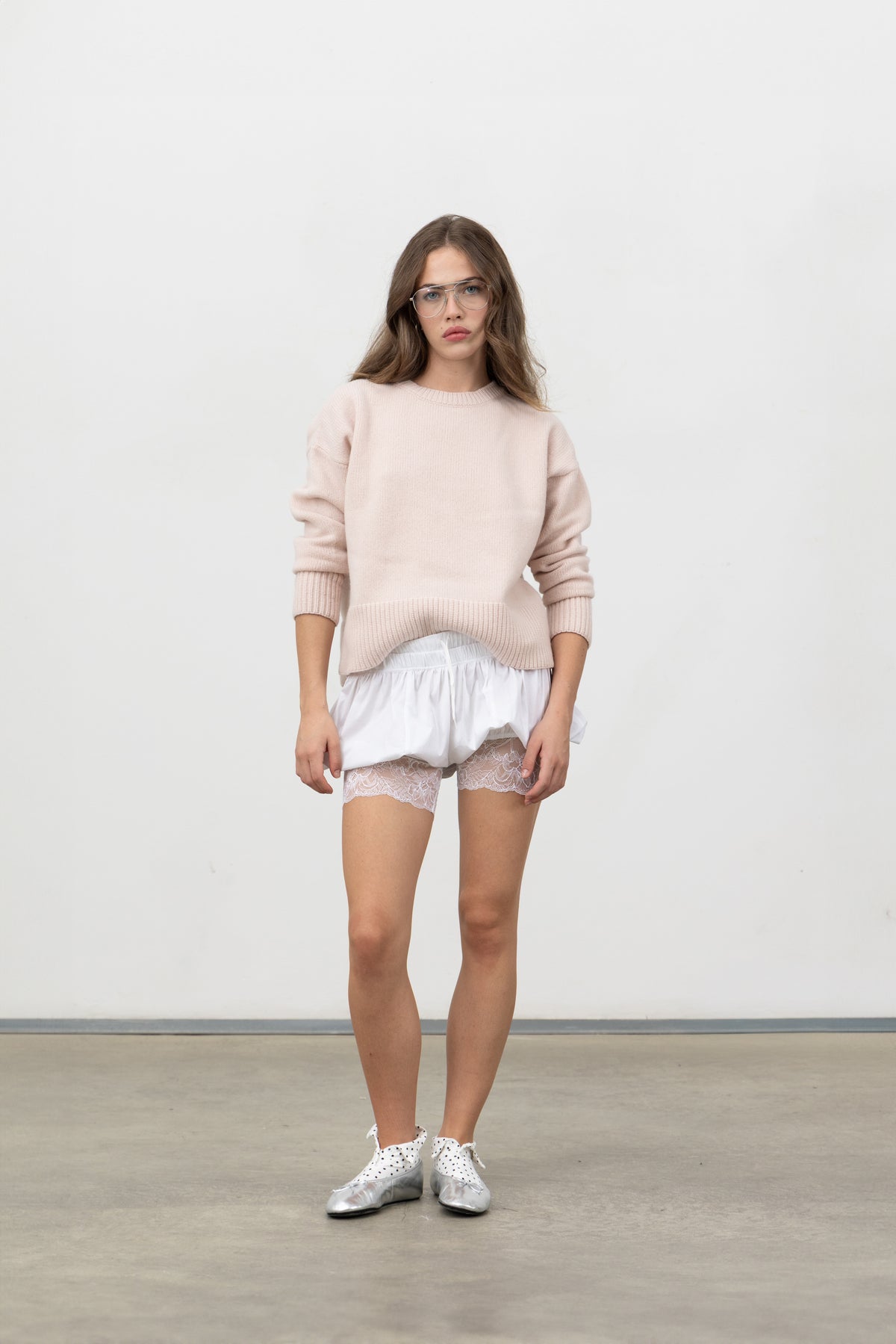 Full-length view of Saint Shorts White styled with a blush knit and sneakers