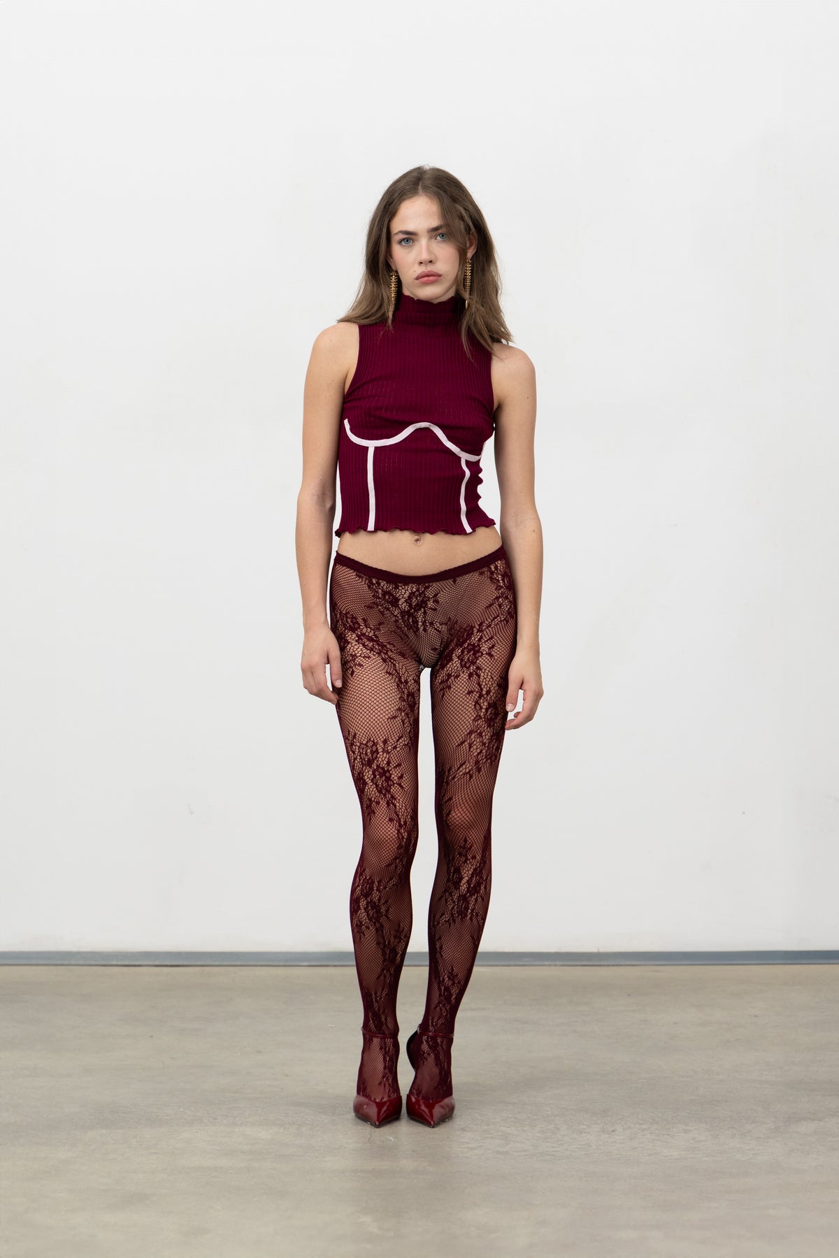 Full-length view of the Dimenticato Malbec sleeveless mock-neck corset top styled with burgundy lace tights