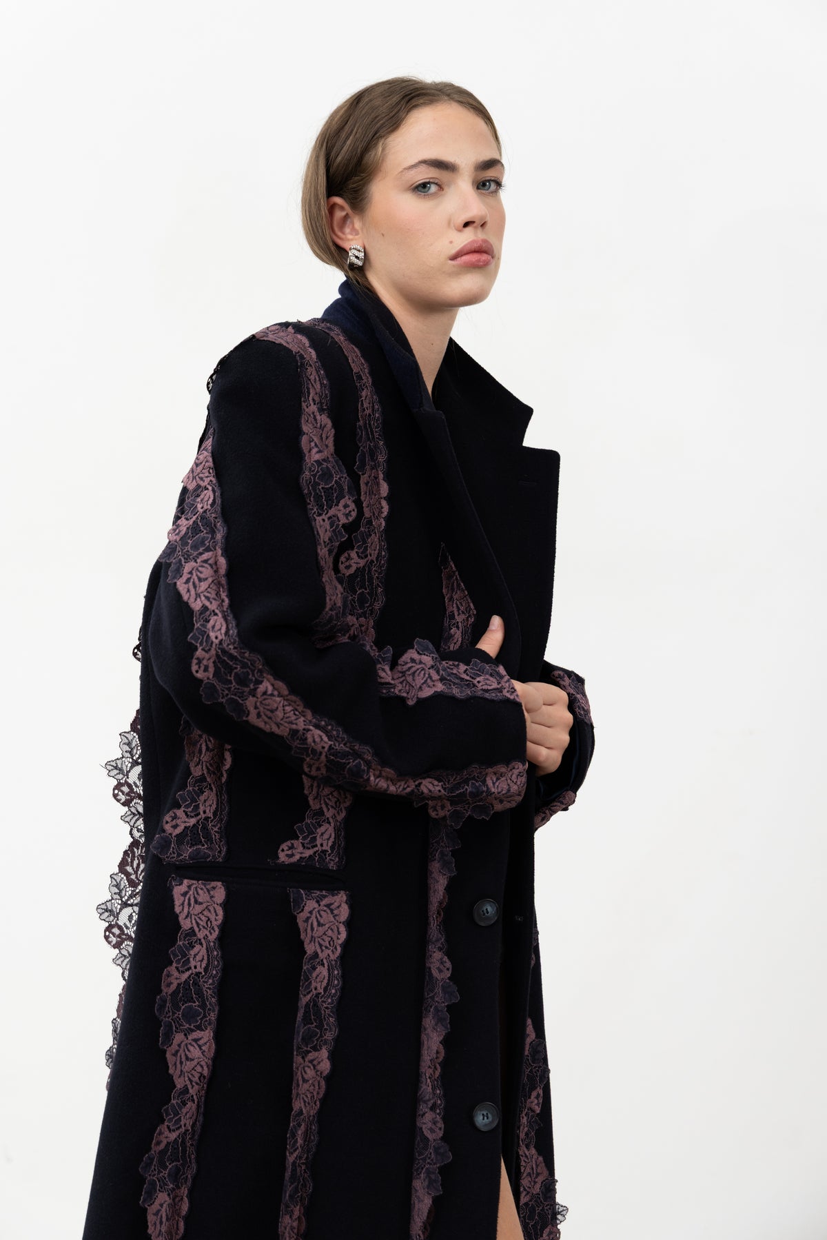 Three-quarter view of the navy wool Rinascimento Coat with lace trim