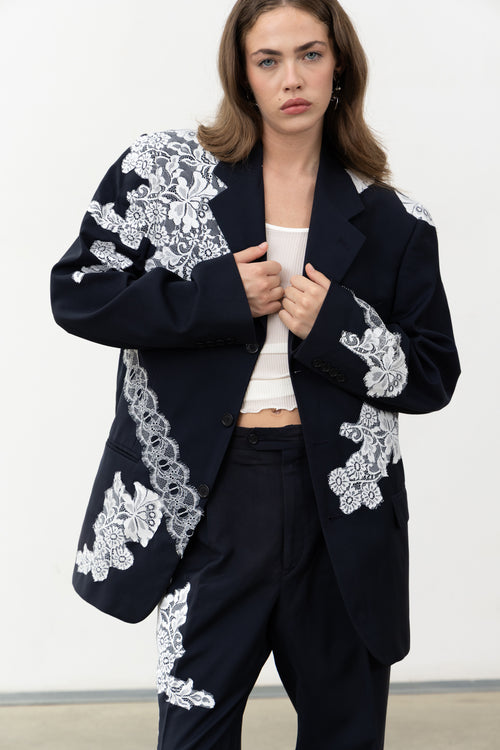 Close-up of the white lace layered on the navy wool Allegoria Blazer