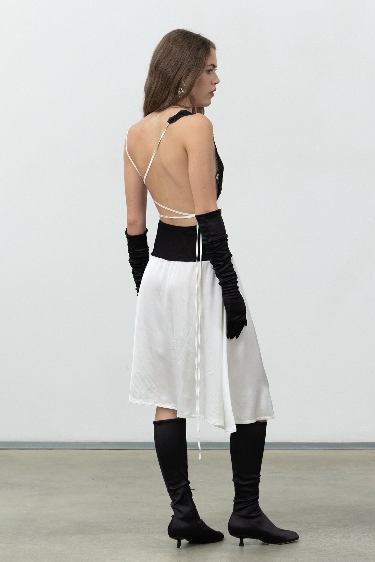 Back view of the Sacro Dress with crossed straps and satin skirt